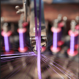 Fabrication d’un cordon en viscose violette sur un métier en bois de 1830, destiné à être terminé en lacet, usine d’Andrezé, 2020
